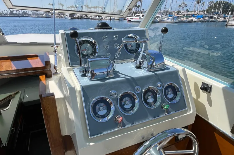 Slide: The Image of 1966 Chris-Craft 27 Commander helm with vintage gauges and controls, docked in a marina. - 25