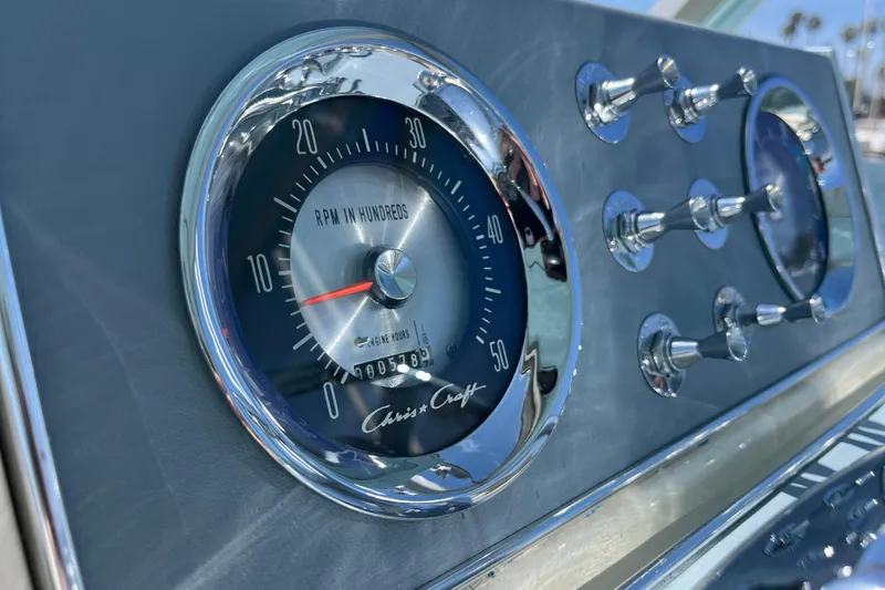 Slide: The Image of 1966 Chris-Craft 27 Commander dashboard with RPM gauge and chrome switches. - 28