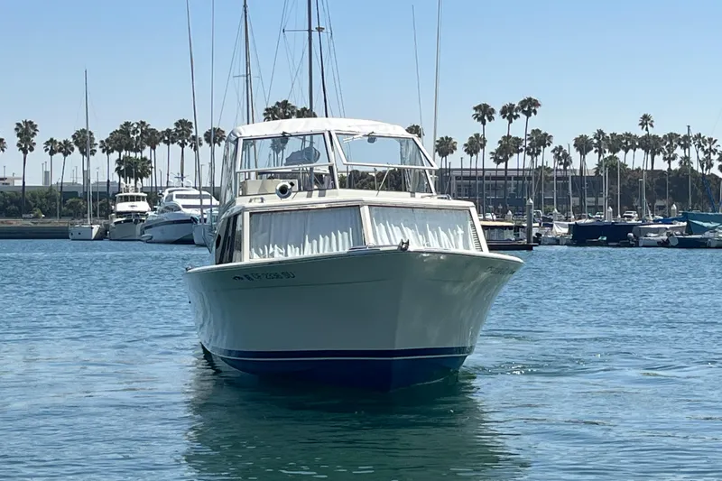 Slide: The Image of 1966 Chris-Craft 27 Commander boat on water, marina background with palm trees. - 3