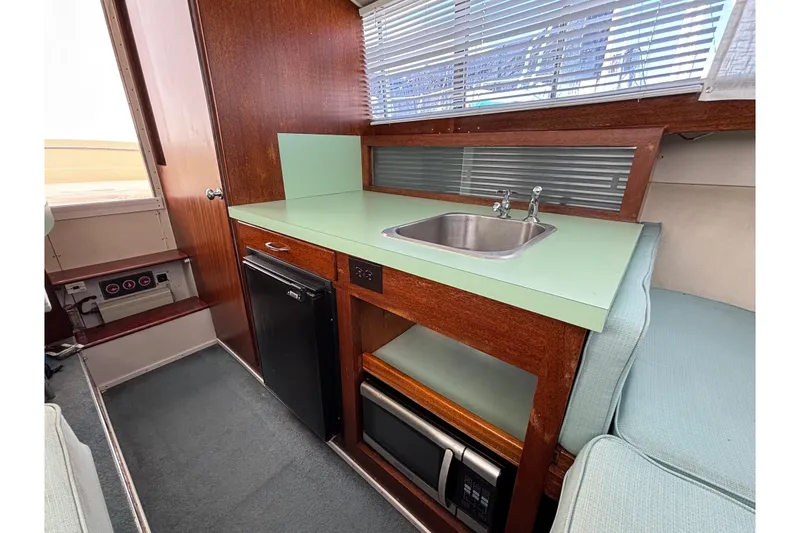 Slide: The Image of 1966 Chris-Craft 27 Commander interior with kitchenette, sink, and appliances. - 37