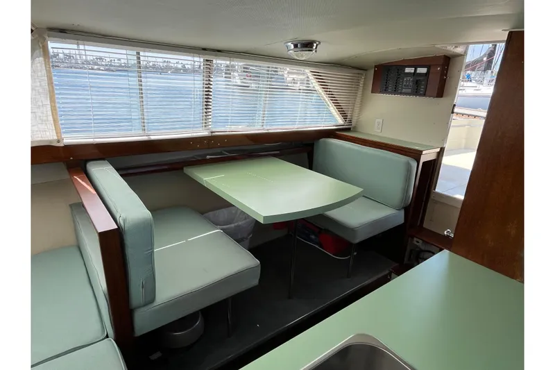 Slide: The Image of 1966 Chris-Craft 27 Commander interior with mint green seating and table, overlooking marina. - 38