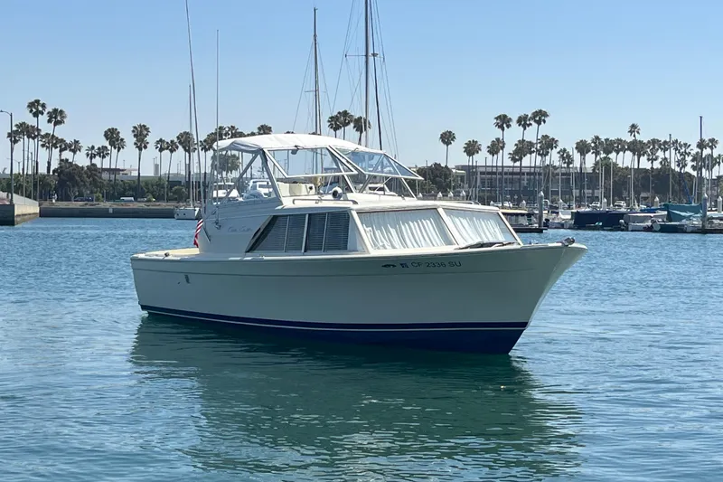 Slide: The Image of 1966 Chris-Craft 27 Commander boat on calm water with marina background. - 4