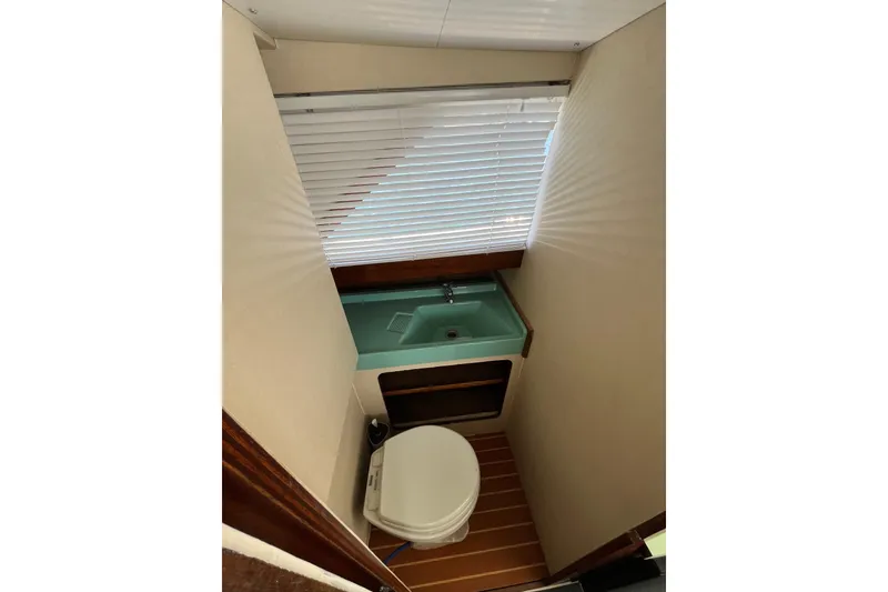 Slide: The Image of 1966 Chris-Craft 27 Commander boat bathroom with sink, toilet, and window blinds. - 41