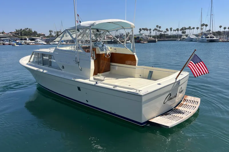 Slide: The Image of 1966 Chris-Craft 27 Commander boat docked in a marina, featuring classic design and American flag. - 7