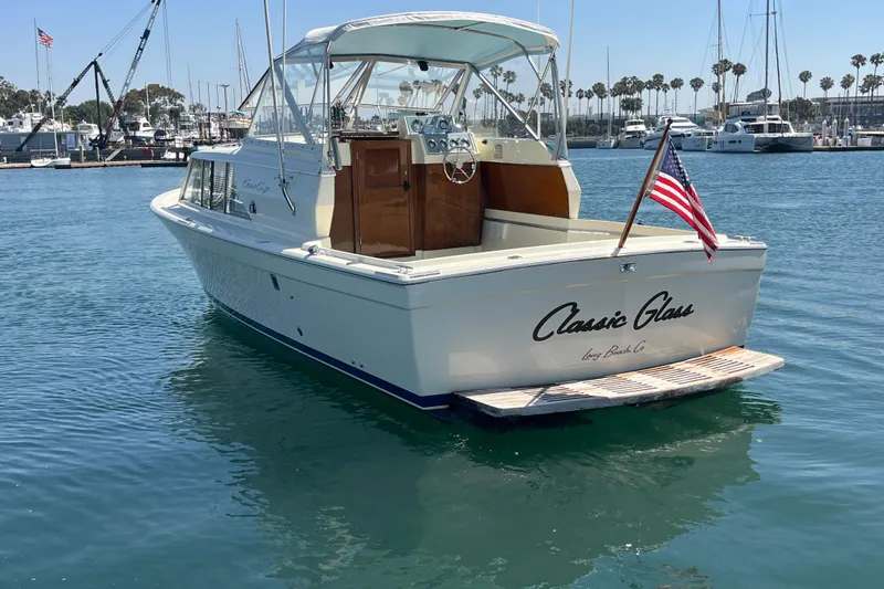 Slide: The Image of 1966 Chris-Craft 27 Commander boat docked in marina, displaying American flag. - 8