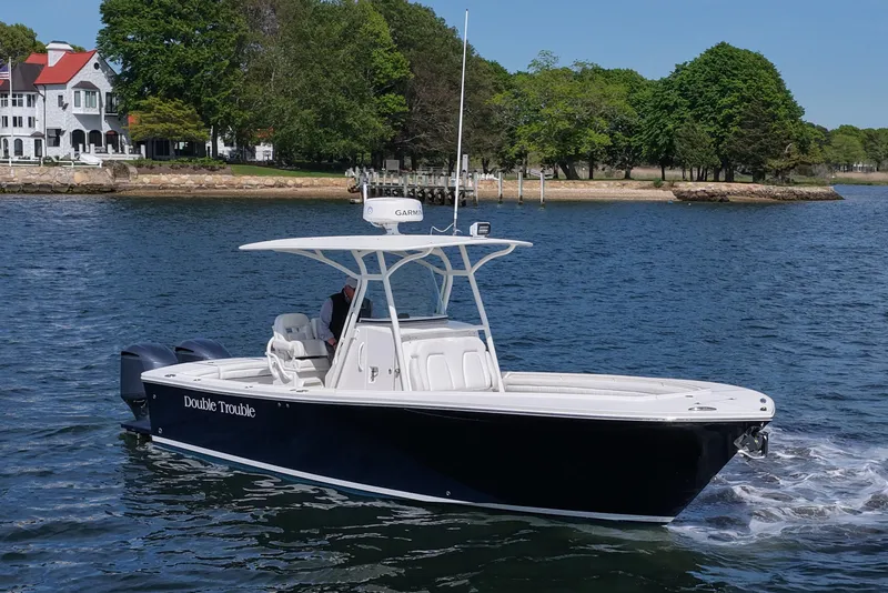 Slide: The Image of 2019 Regulator 28 Forward Seating boat cruising near a scenic shoreline. - 10