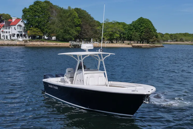 Slide: The Image of 2019 Regulator 28 Forward Seating boat on water near scenic shoreline. - 11