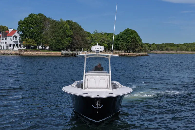 Slide: The Image of 2019 Regulator 28 Forward Seating boat on water near shoreline with trees. - 12
