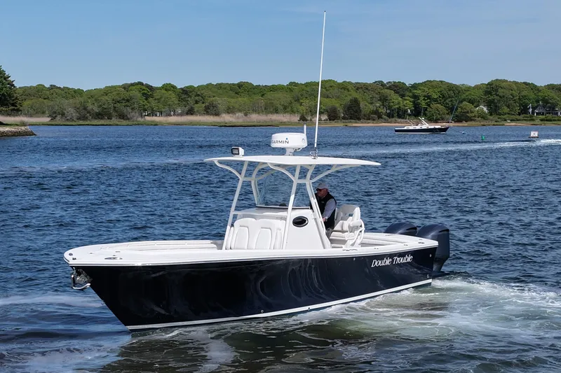 Slide: The Image of 2019 Regulator 28 Forward Seating boat cruising on a scenic waterway. - 2