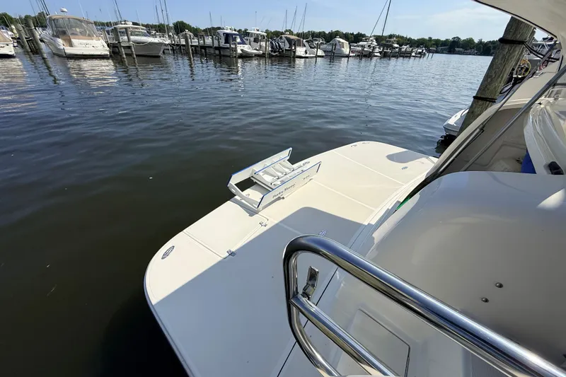 Slide: The Image of 1995 Tiara Yachts 4000 Express docked at marina, showcasing swim platform and railing. - 10