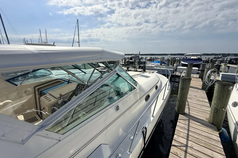 Slide: The Image of 1995 Tiara Yachts 4000 Express docked at marina under a partly cloudy sky. - 13