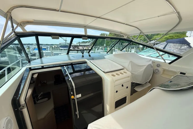 Slide: The Image of 1995 Tiara Yachts 4000 Express cockpit with covered seating and marina view. - 17