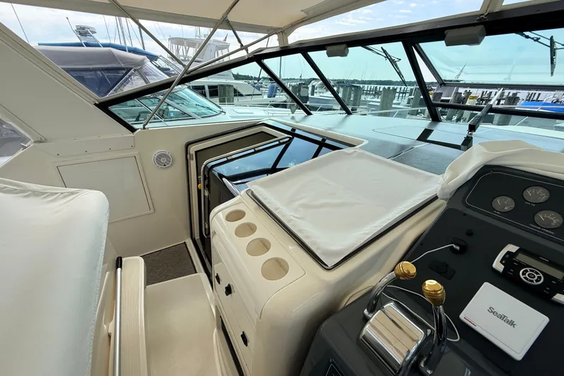 Slide: The Image of 1995 Tiara Yachts 4000 Express cockpit with helm controls and marina view. - 26