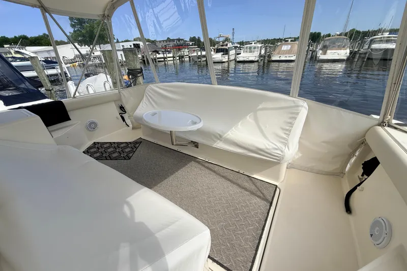 Slide: The Image of 1995 Tiara Yachts 4000 Express interior with white seating, table, and marina view. - 28