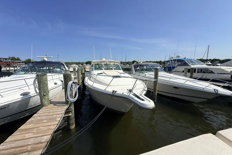 Slide: The Image of 1995 Tiara Yachts 4000 Express docked at marina under clear blue sky. - 3