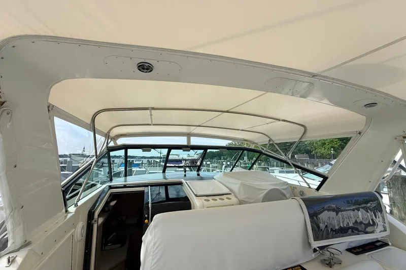 Slide: The Image of 1995 Tiara Yachts 4000 Express interior with helm and seating area under canopy. - 30