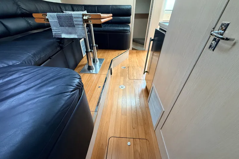 Slide: The Image of Interior of a 1995 Tiara Yachts 4000 Express with sleek wood flooring and black seating. - 41