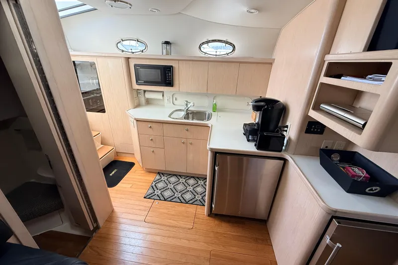 Slide: The Image of Interior of 1995 Tiara Yachts 4000 Express, featuring kitchenette with microwave and coffee maker. - 44