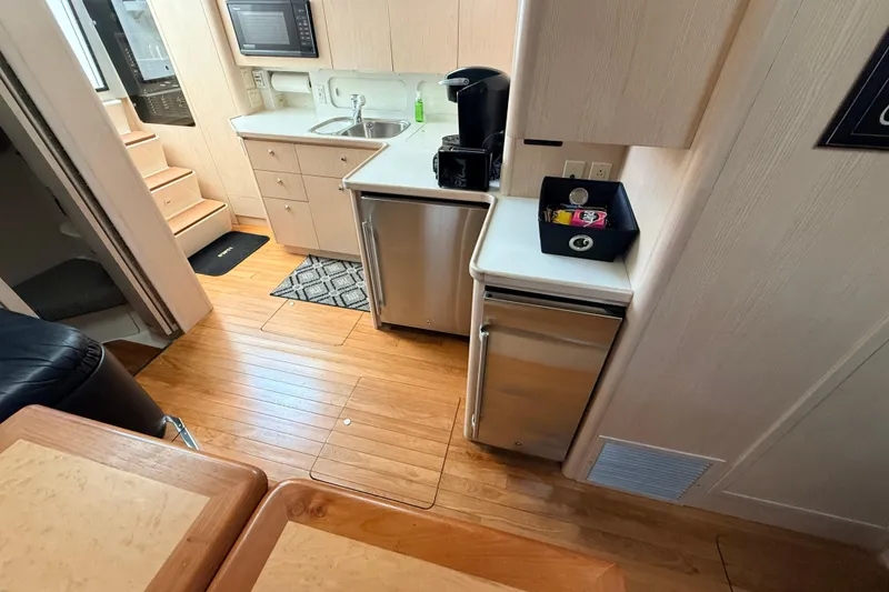 Slide: The Image of Interior of 1995 Tiara Yachts 4000 Express, featuring kitchenette with wood flooring and modern appliances. - 45