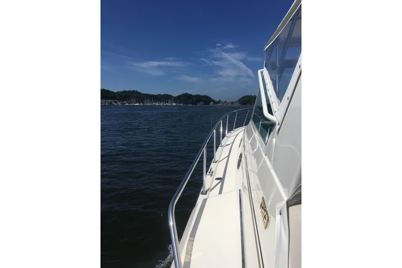 Slide: The Image of 1995 Tiara Yachts 4000 Express cruising on a sunny day, scenic water view. - 6