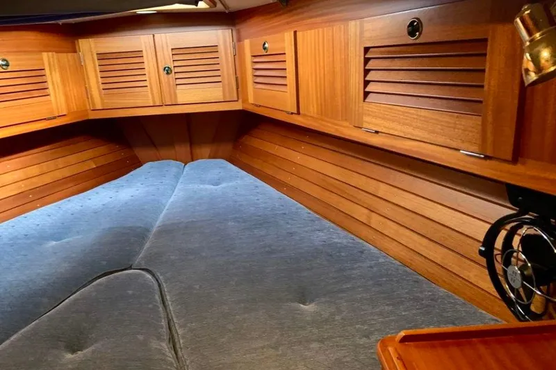 Slide: The Image of Interior cabin of a 1997 Hallberg-Rassy 39 yacht with wooden paneling and cozy bedding. - 13