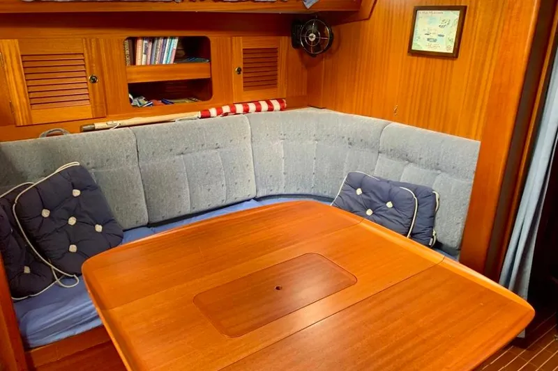 Slide: The Image of Cozy interior of 1997 Hallberg-Rassy 39 sailboat with wooden table and cushioned seating. - 14