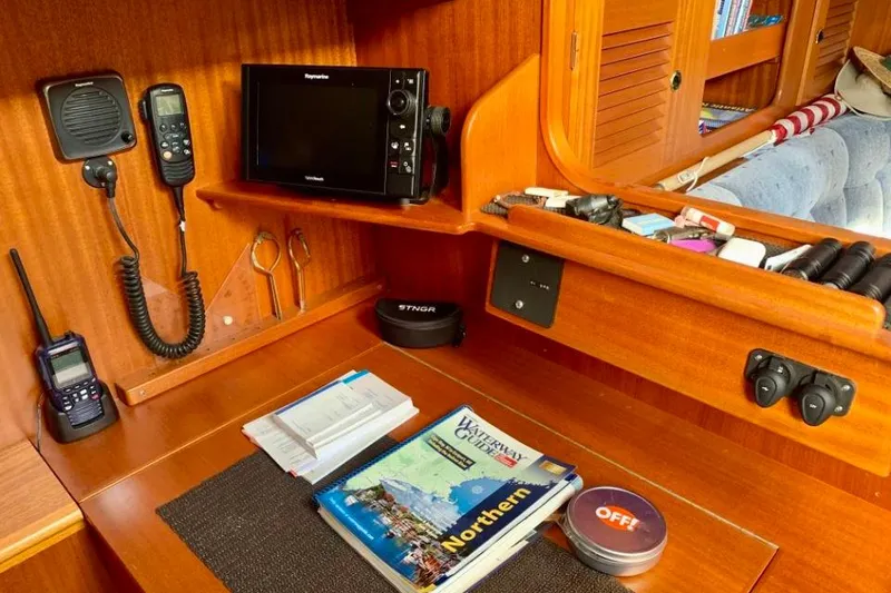 Slide: The Image of Navigation station on a 1997 Hallberg-Rassy 39 yacht with communication equipment and guides. - 16