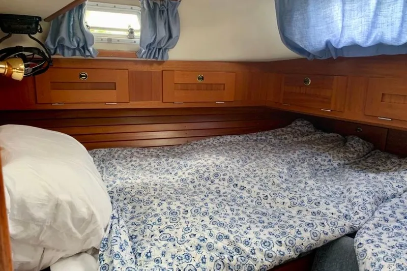 Slide: The Image of Cozy cabin interior of 1997 Hallberg-Rassy 39 sailboat with wooden cabinetry and floral bedding. - 21