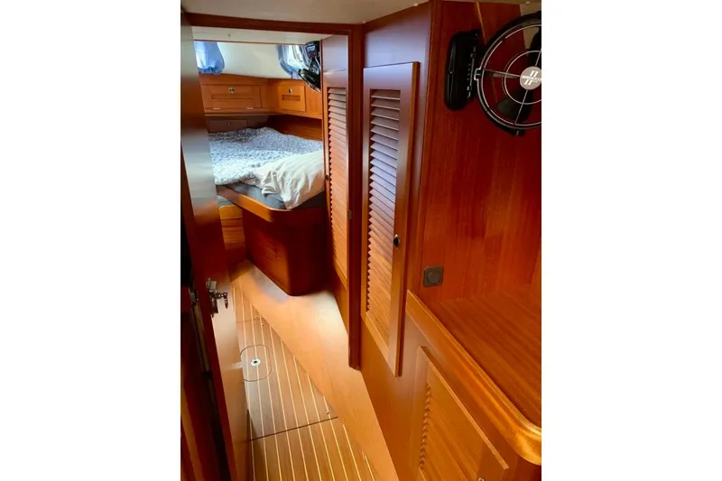 Slide: The Image of Interior of 1997 Hallberg-Rassy 39 sailboat, featuring wooden cabinetry and cozy sleeping quarters. - 22