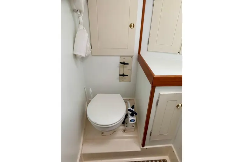 Slide: The Image of Bathroom interior of a 1997 Hallberg-Rassy 39 yacht, featuring a compact marine toilet. - 23