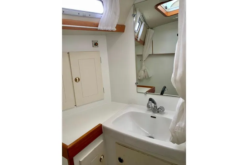 Slide: The Image of Bathroom interior of 1997 Hallberg-Rassy 39 yacht with sink, mirror, and storage cabinets. - 24