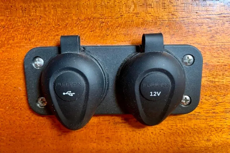 Slide: The Image of USB and 12V outlets on a 1997 Hallberg-Rassy 39 yacht's wooden panel. - 29