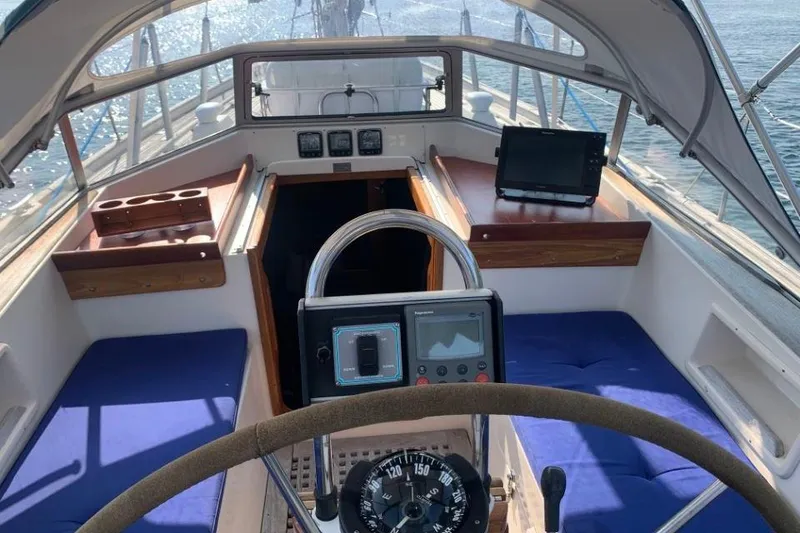 Slide: The Image of Cockpit of a 1997 Hallberg-Rassy 39 sailboat with navigation equipment and blue seating. - 6