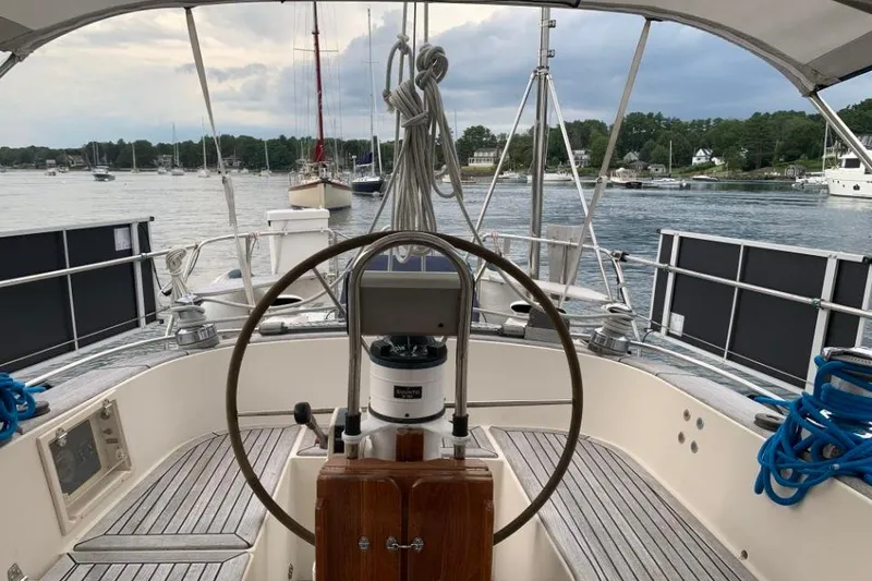 Slide: The Image of Cockpit view of a 1997 Hallberg-Rassy 39 sailboat docked in a serene marina. - 7