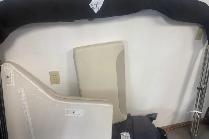 Slide: The Image of 2023 Boston Whaler 160 Super Sport boat parts, including cushions and accessories, displayed indoors. - 10