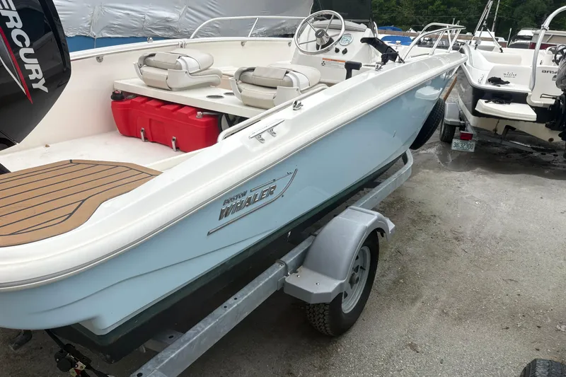Slide: The Image of 2023 Boston Whaler 160 Super Sport boat on trailer, featuring sleek design and Mercury engine. - 2