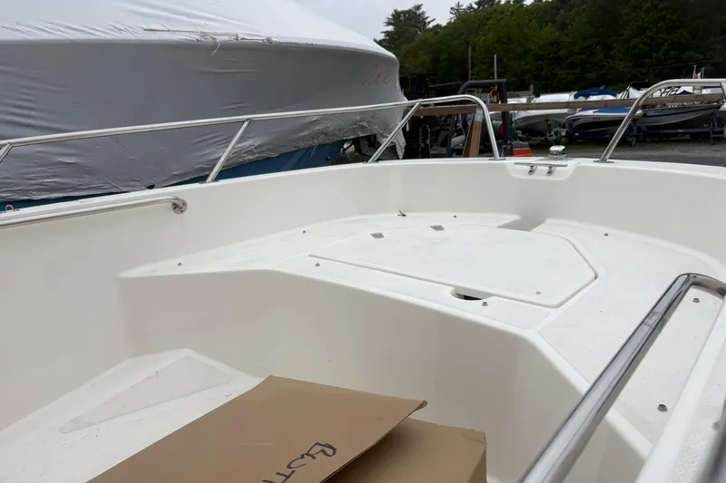 Slide: The Image of 2023 Boston Whaler 160 Super Sport boat interior with white seating and railing. - 5