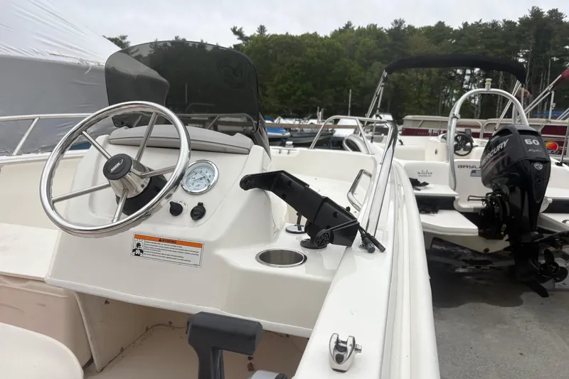 Slide: The Image of 2023 Boston Whaler 160 Super Sport boat interior with steering wheel and controls. - 6