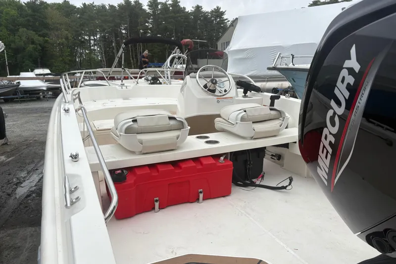 Slide: The Image of 2023 Boston Whaler 160 Super Sport boat with Mercury engine, docked outdoors. - 7