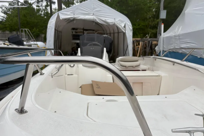 Slide: The Image of 2023 Boston Whaler 160 Super Sport boat in storage, featuring sleek interior and protective cover. - 8