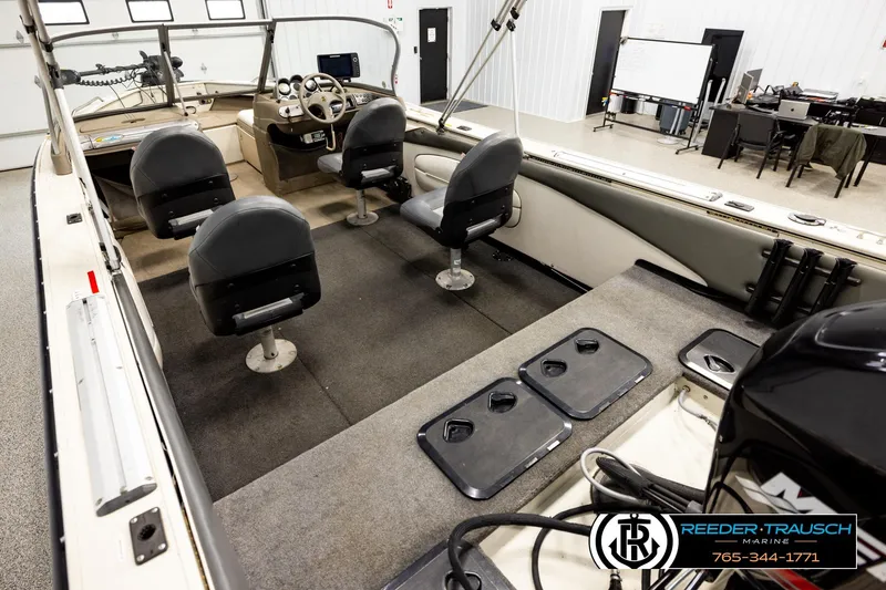 Slide: The Image of 2004 Crestliner 2050 Sportfish boat interior with seating and control panel in showroom. - 10