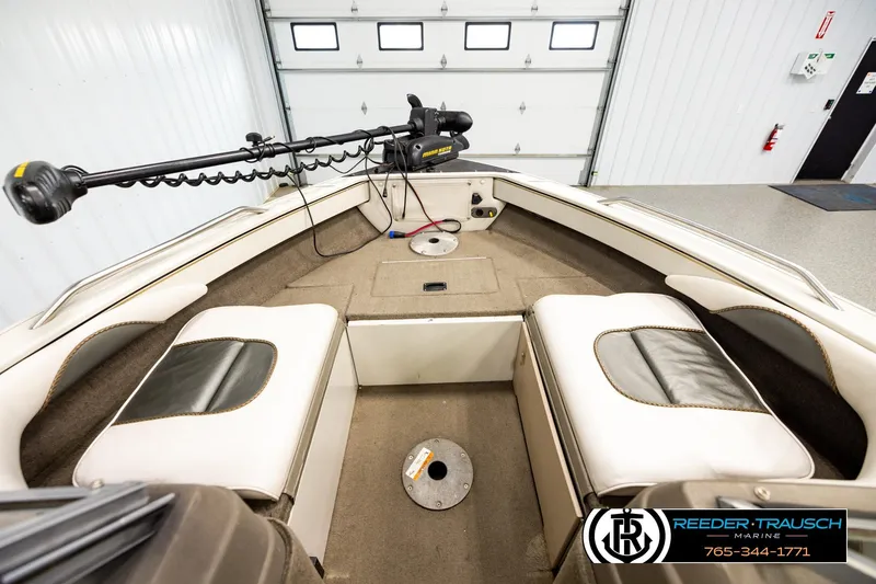 Slide: The Image of 2004 Crestliner 2050 Sportfish boat interior with seating and trolling motor in a garage. - 14