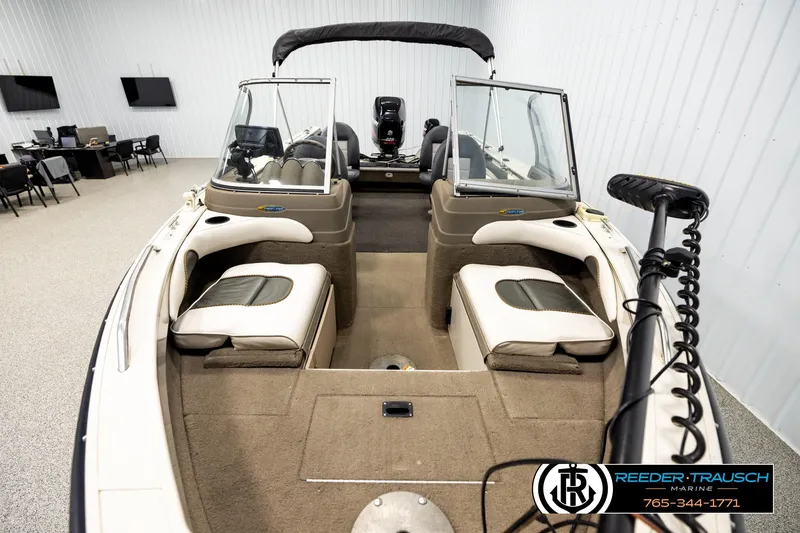Slide: The Image of 2004 Crestliner 2050 Sportfish boat interior with seating and steering console in showroom. - 15
