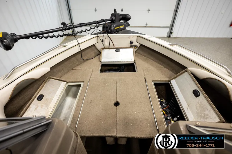 Slide: The Image of 2004 Crestliner 2050 Sportfish boat interior with storage compartments and trolling motor. - 25