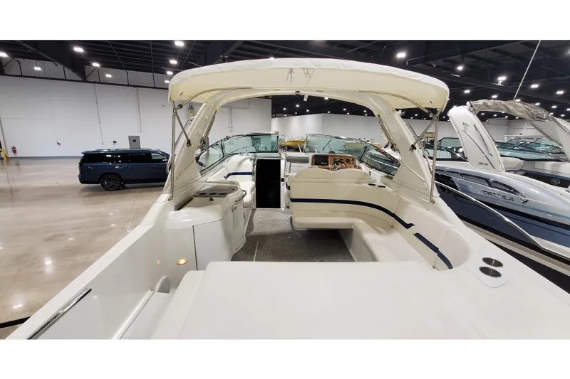 Slide: The Image of 2006 Formula 330 Sun Sport boat interior with seating and helm in showroom. - 12