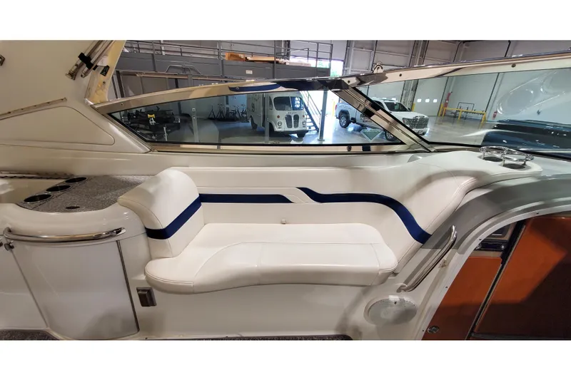 Slide: The Image of 2006 Formula 330 Sun Sport interior with white seating and blue accents in a showroom. - 22