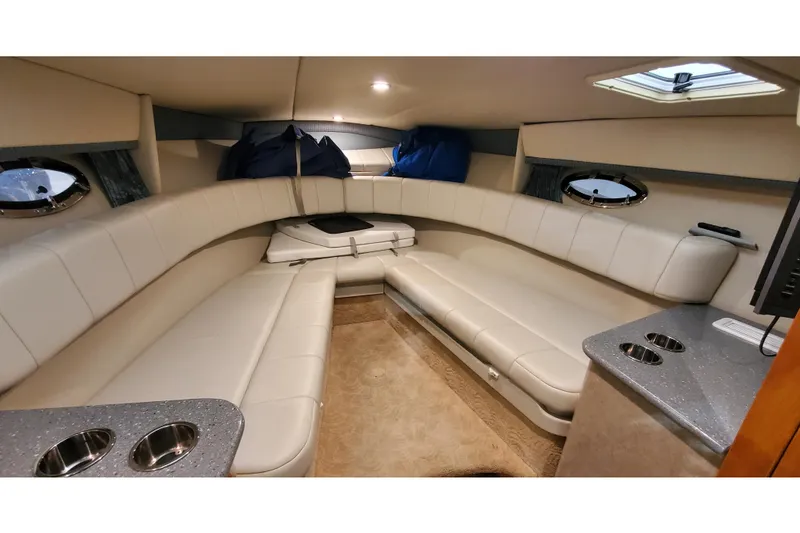 Slide: The Image of Interior of 2006 Formula 330 Sun Sport boat with beige seating and portholes. - 26