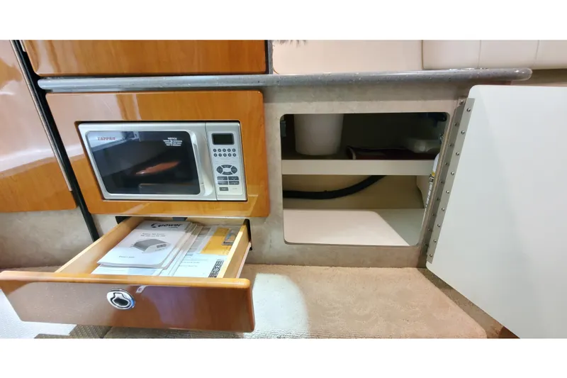 Slide: The Image of 2006 Formula 330 Sun Sport interior with microwave, open drawer, and storage cabinet. - 31