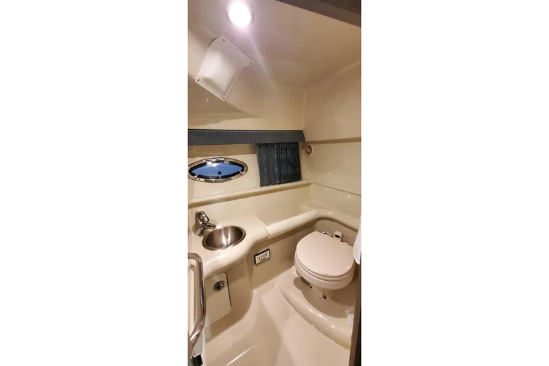 Slide: The Image of 2006 Formula 330 Sun Sport boat bathroom with sink, toilet, and porthole window. - 33