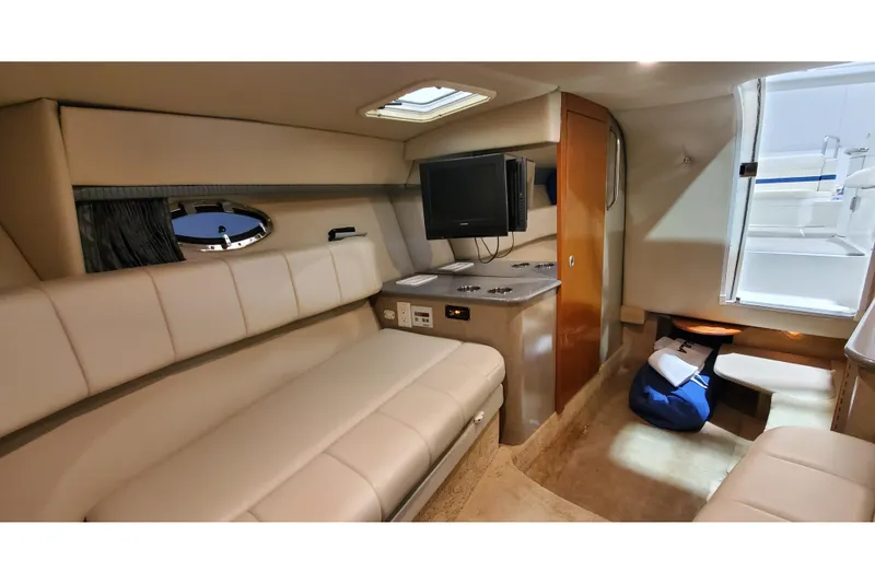 Slide: The Image of Interior of 2006 Formula 330 Sun Sport boat, featuring beige seating, TV, and compact cabin amenities. - 37